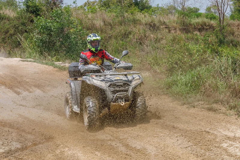 ATV rider splashing through a muddy patch