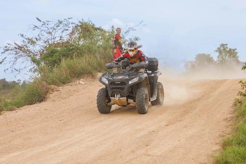 ATV rider kicking up dust on a winding dirt track
